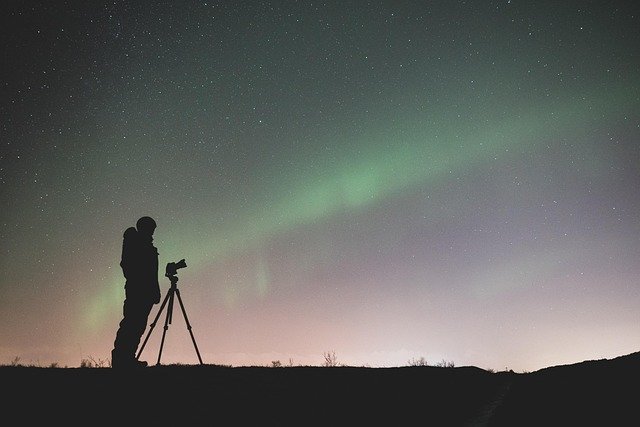 Person photographing northern lights at night. Hessdalen Lights.